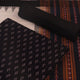Detail of the black Sambalpuri cotton dress material's matching blouse piece with motifs.