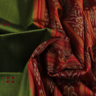 Green Khandua silk saree draped, showcasing its butta pattern and red accents.