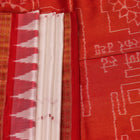 Close-up of white and red silk Bomkai saree fabric texture with butta pattern.