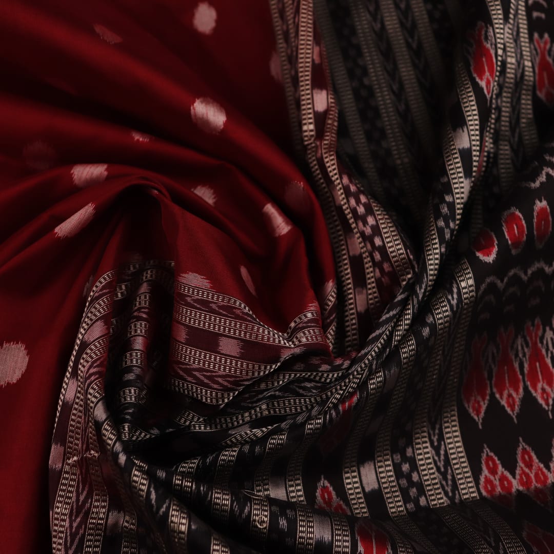 Close-up view of maroon and black silk Sambalpuri saree fabric showcasing intricate motifs