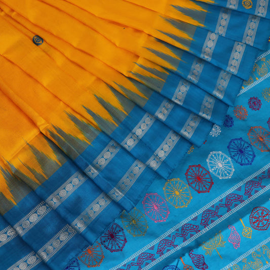 Close-up of the yellow Bomkai silk saree fabric texture, revealing its intricate weave and butta pattern.