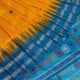 Close-up of the yellow Bomkai silk saree fabric texture, revealing its intricate weave and butta pattern.