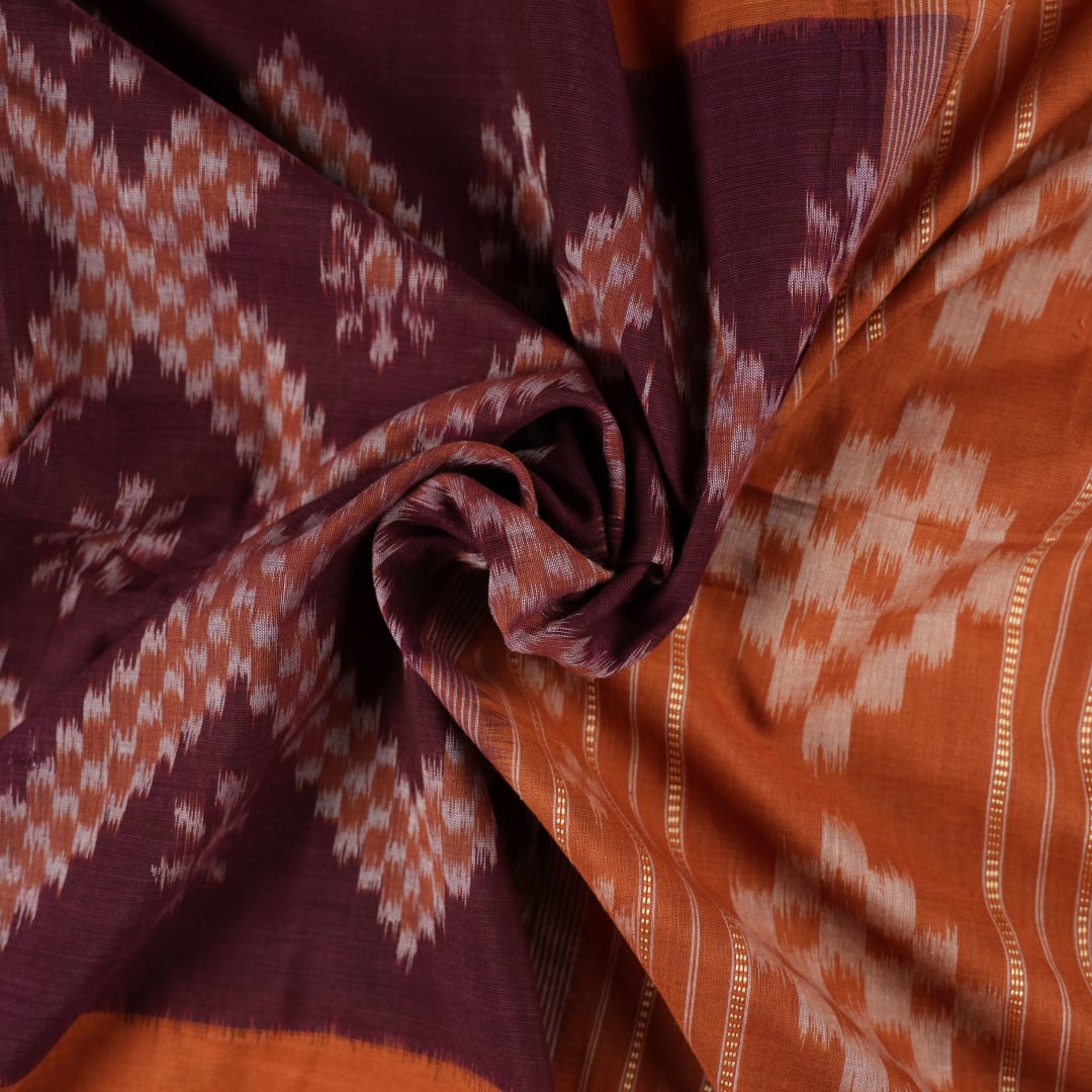 Model draped in a maroon and brown Sambalpuri cotton saree showcasing traditional Odisha handloom style.
