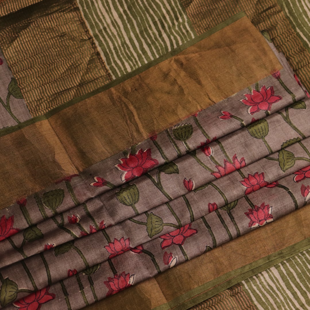 Close-up view of grey Tussar silk saree with intricate motifs on its textured fabric