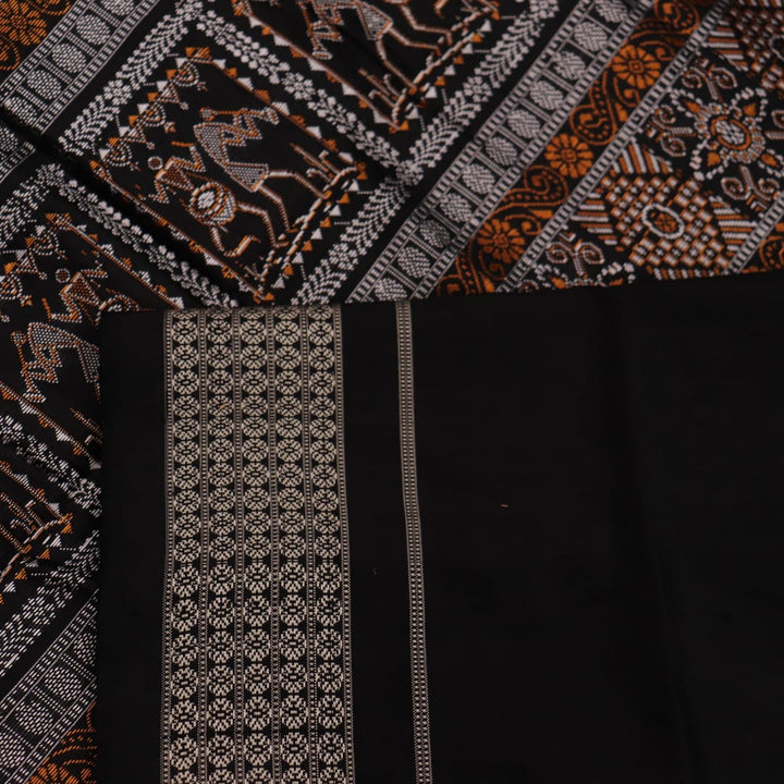 Close-up view of the silken texture of the Sambalpuri silk saree, showcasing green and black woven motifs.