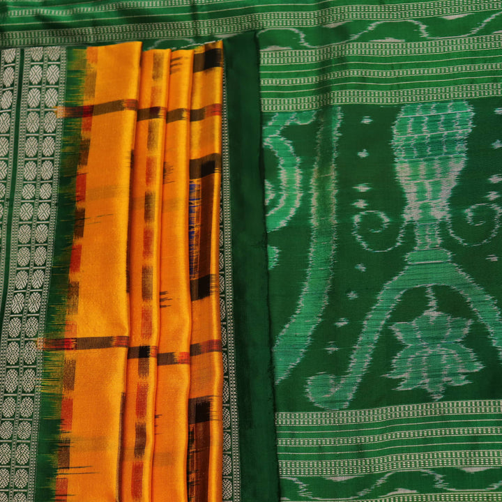 Close-up of yellow Sambalpuri silk saree fabric showing intricate motifs and woven texture.