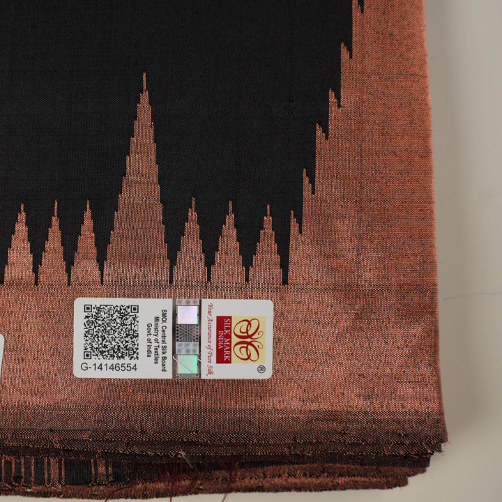 Extreme close-up showing the rich black and brown Sambalpuri Silk fabric texture and intricate handloom weave.