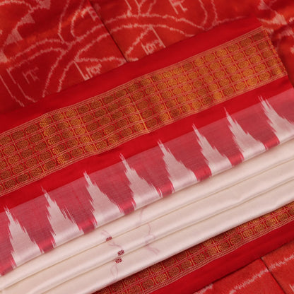Close-up of white and red silk Bomkai saree fabric texture with butta pattern.
