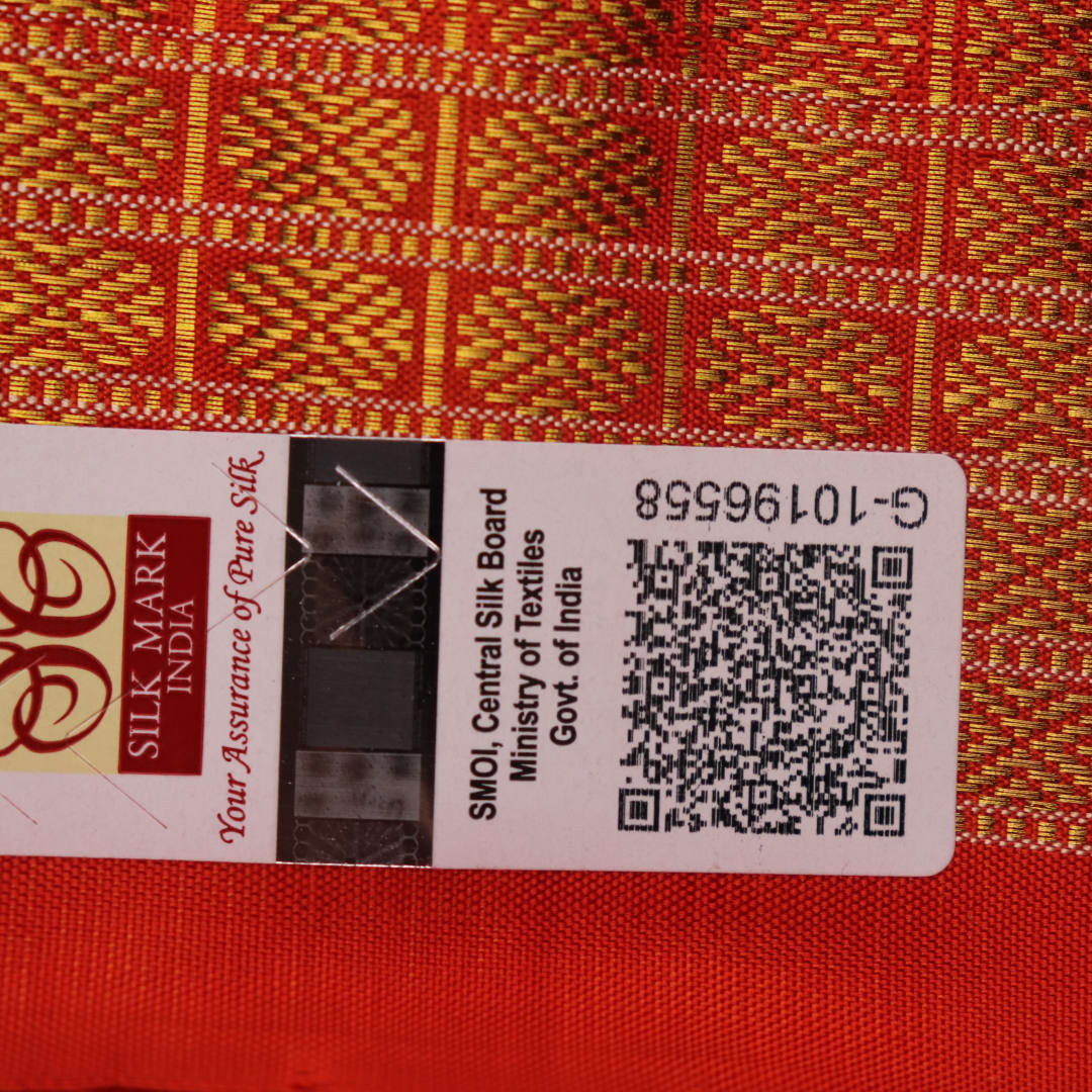 Close-up of maroon and orange Sambalpuri silk saree fabric texture, showcasing handloom weave and motif details.