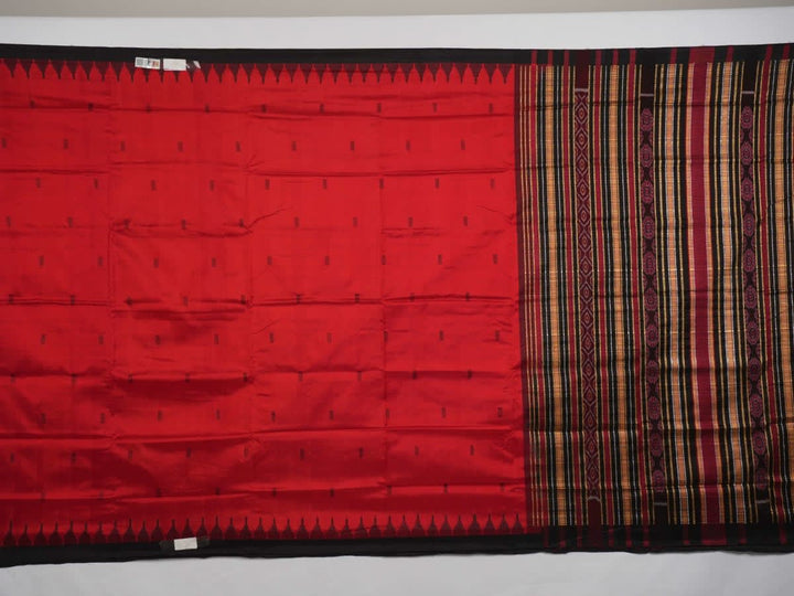 Detailed view of hand-woven silk fabric texture and butta patterns on a red Sambalpuri saree.