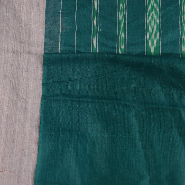 Close-up of textured grey and green Tussar silk fabric used in a plain pattern saree