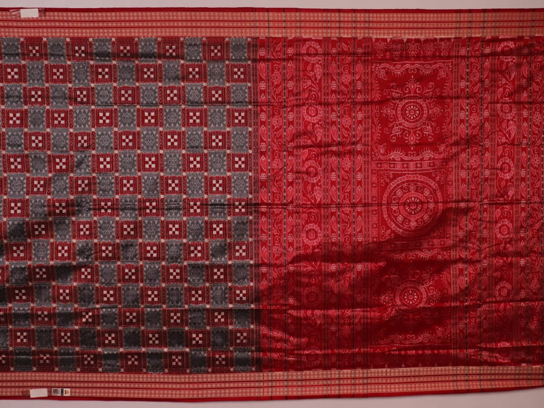 Close-up of grey Sambalpuri silk saree fabric showing intricate woven motifs and texture.