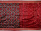 Close-up of grey Sambalpuri silk saree fabric showing intricate woven motifs and texture.