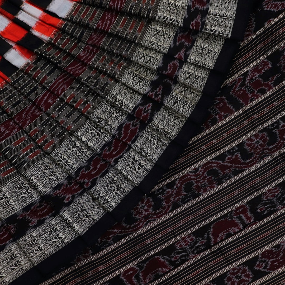 Close-up view of the smooth, lustrous texture of black silk fabric with a Pasapalli pattern in the Sambalpuri style