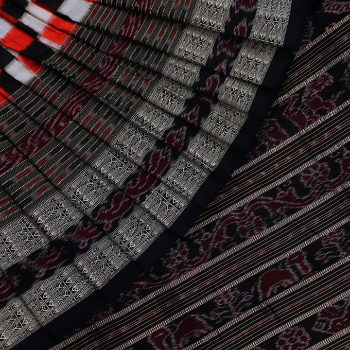 Close-up view of the smooth, lustrous texture of black silk fabric with a Pasapalli pattern in the Sambalpuri style