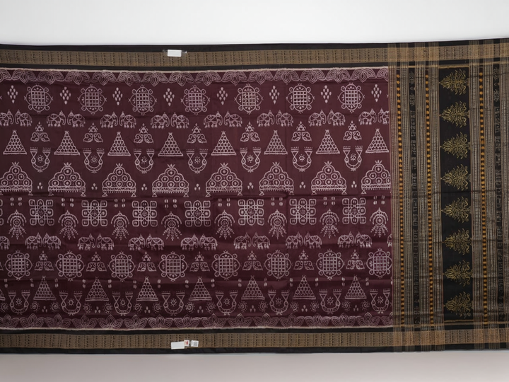 Micro close-up of the maroon Sambalpuri silk fabric, revealing its luxurious texture and handloom weave.