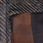 Close-up of the natural slub texture of grey printed Tussar silk saree fabric.