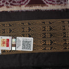 Micro close-up of the maroon Sambalpuri silk fabric, revealing its luxurious texture and handloom weave.