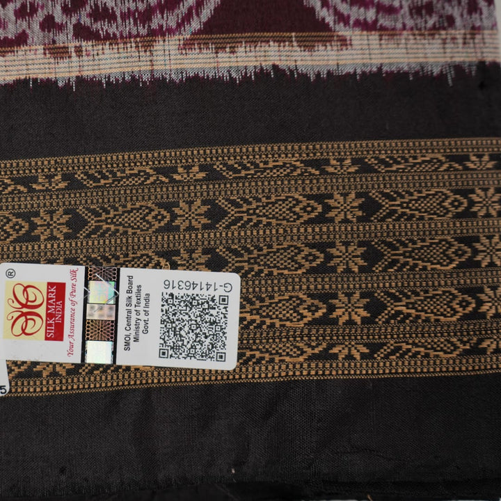 Micro close-up of the maroon Sambalpuri silk fabric, revealing its luxurious texture and handloom weave.