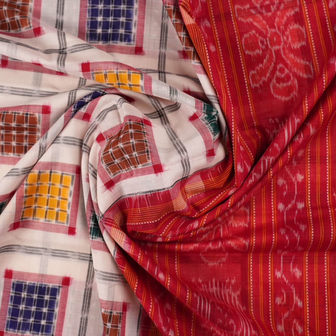 Model wearing a white and red Sambalpuri cotton saree with traditional motifs, styled for an elegant look.