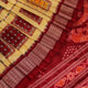 Close-up of multicolored Sambalpuri silk saree fabric texture showing intricate weave and maroon accents.