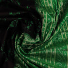 Close-up showcase of the exquisite silk texture with intricate motifs in a black and green Sambalpuri saree.