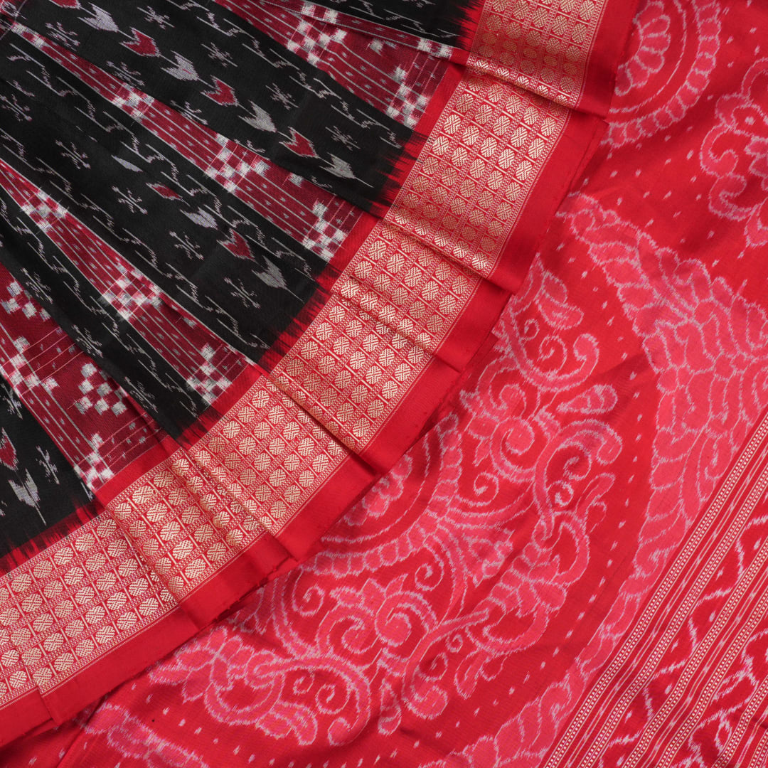 Close-up of the rich, smooth texture of the black Sambalpuri silk saree fabric.