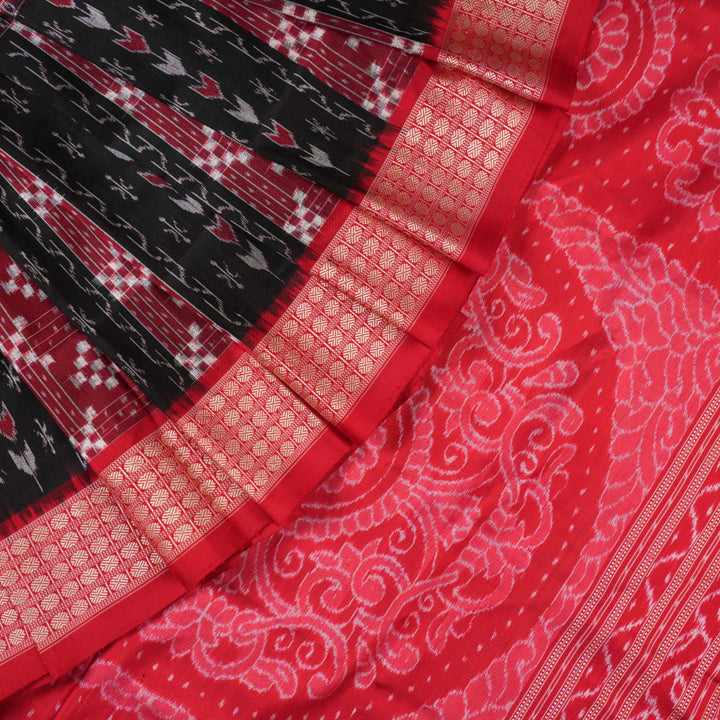 Close-up of the rich, smooth texture of the black Sambalpuri silk saree fabric.