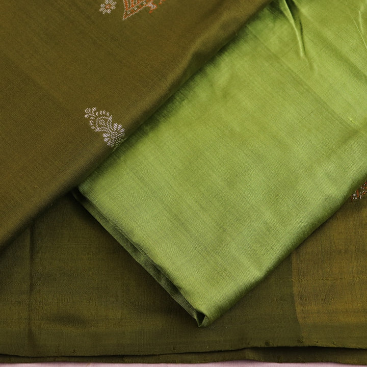 Close-up of the green Bomkai silk dress material's blouse piece with butta pattern.