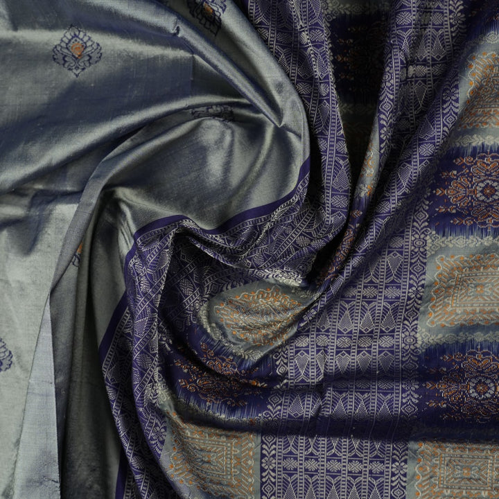 Close-up of luxurious Bomkai Silk Saree fabric texture, highlighting grey and blue handloom weave.