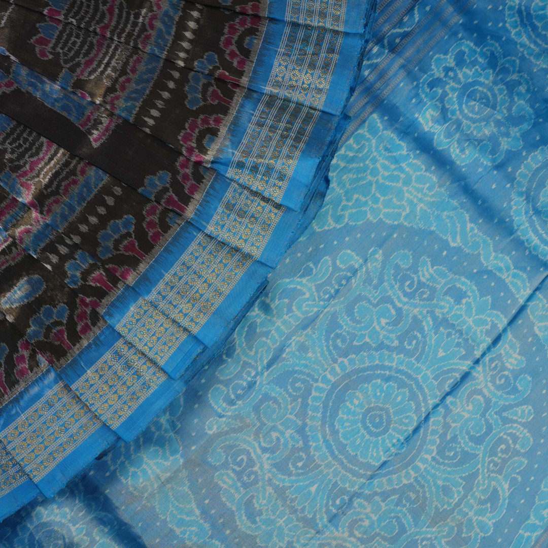 Close-up of Sambalpuri silk saree fabric, revealing rich blue multi-color weave texture and tissue motifs.
