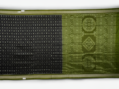 Close-up of the luxurious black and green Sambalpuri silk fabric texture and weave.