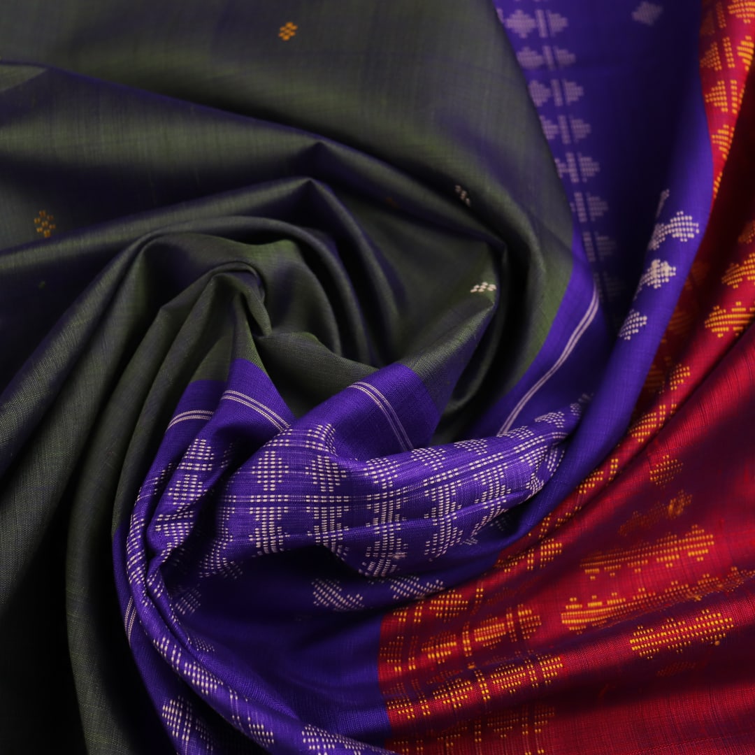 Close-up of the green silk fabric with a butta pattern in the Berhampuri saree