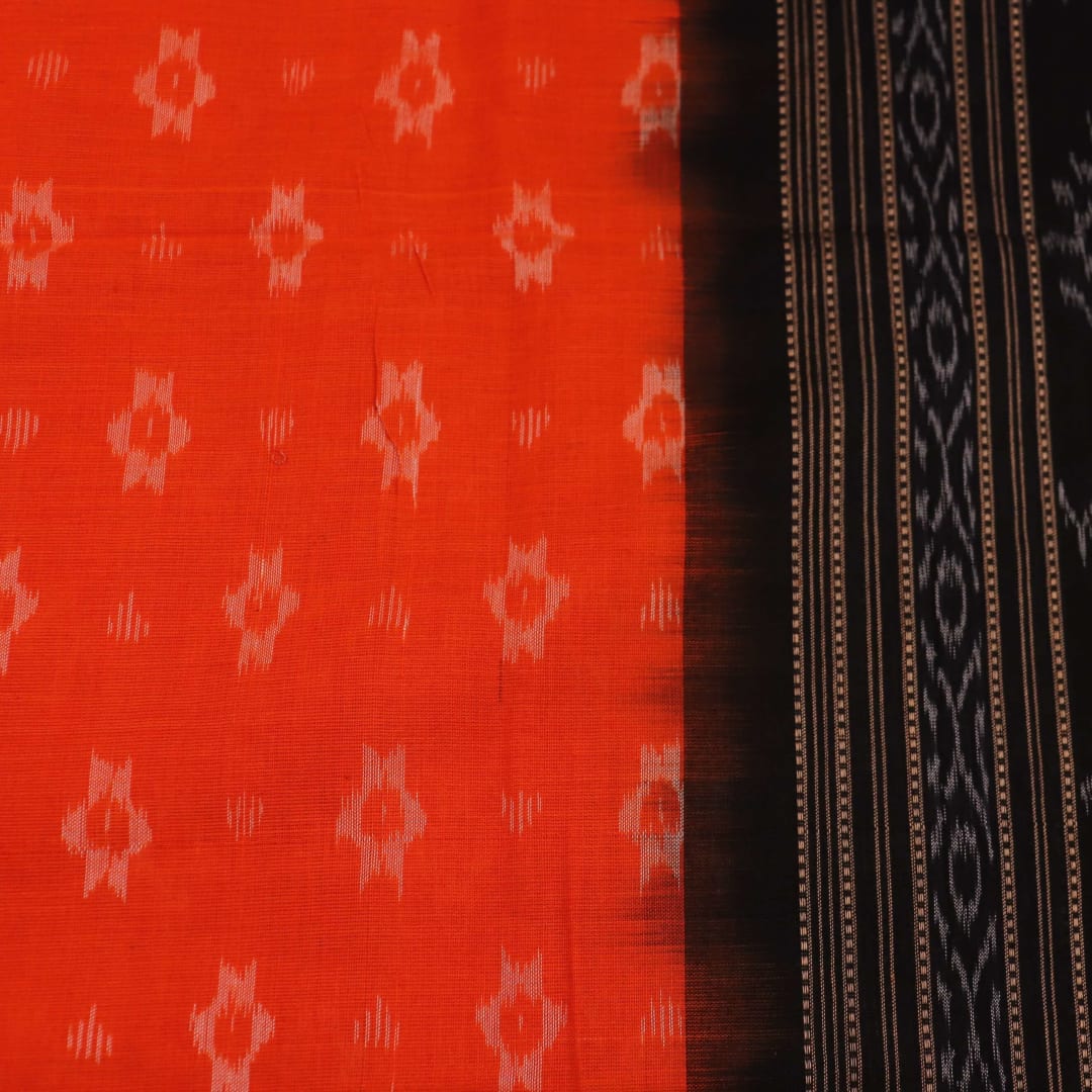 Full body view of a folded Sambalpuri cotton dupatta in orange with bold black motifs.