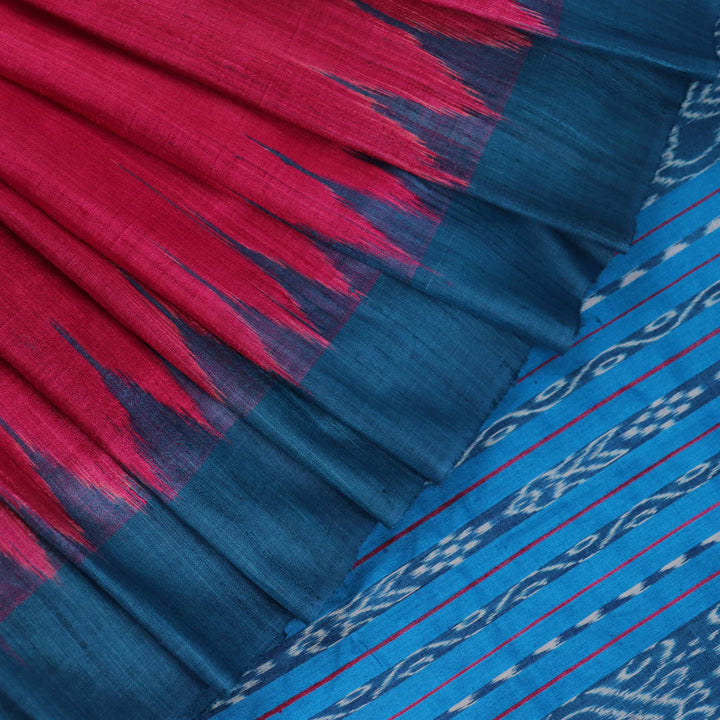 Close-up shot showcasing the textured weave of the tussar silk fabric of a plain pink and blue saree.