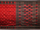 Close-up of maroon silk fabric with delicate butta patterns in black.