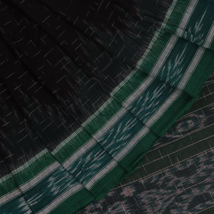 Black and green plain Sambalpuri cotton saree, gracefully draped.