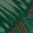 Model wearing a plain green Sambalpuri cotton saree, elegantly draped.
