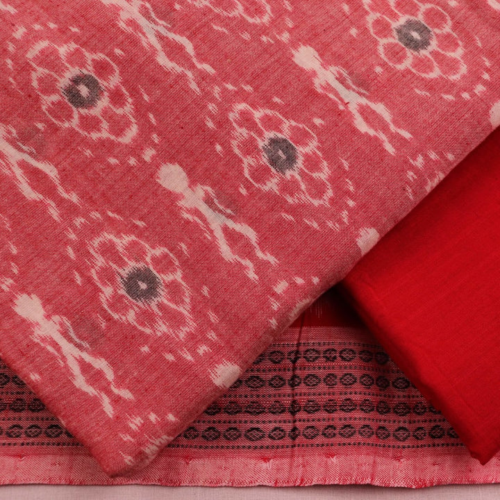 Close-up of red and pink cotton Sambalpuri dress material with intricate motifs.