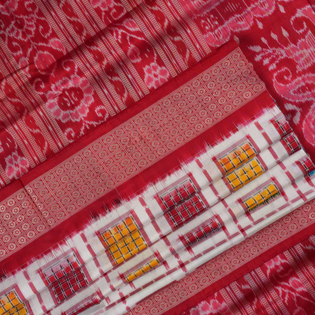 Close-up of the luxurious white Sambalpuri silk saree fabric, highlighting its rich texture and weave.