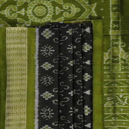 Close-up of the luxurious black and green Sambalpuri silk fabric texture and weave.