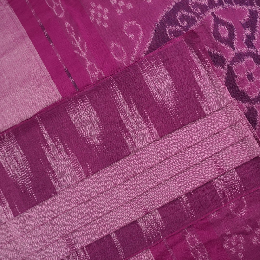 Model draped in a plain pink Sambalpuri cotton saree, styled to show the graceful fall and elegant border.