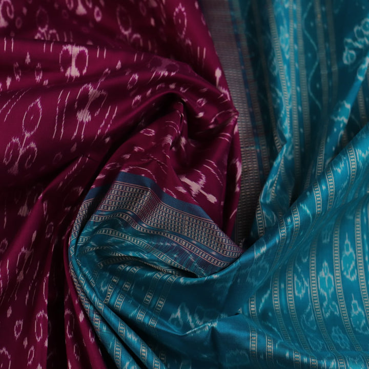 Close-up showcasing the purple and blue silk fabric texture of the Sambalpuri saree with intricate motifs.