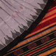Close-up of grey and red Sambalpuri Silk saree fabric texture, highlighting butta pattern weave.