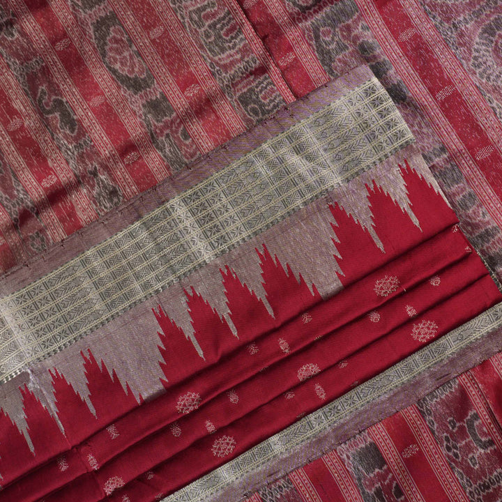 Extreme close-up revealing the rich texture and intricate handloom weave of the maroon and grey Sambalpuri silk fabric.