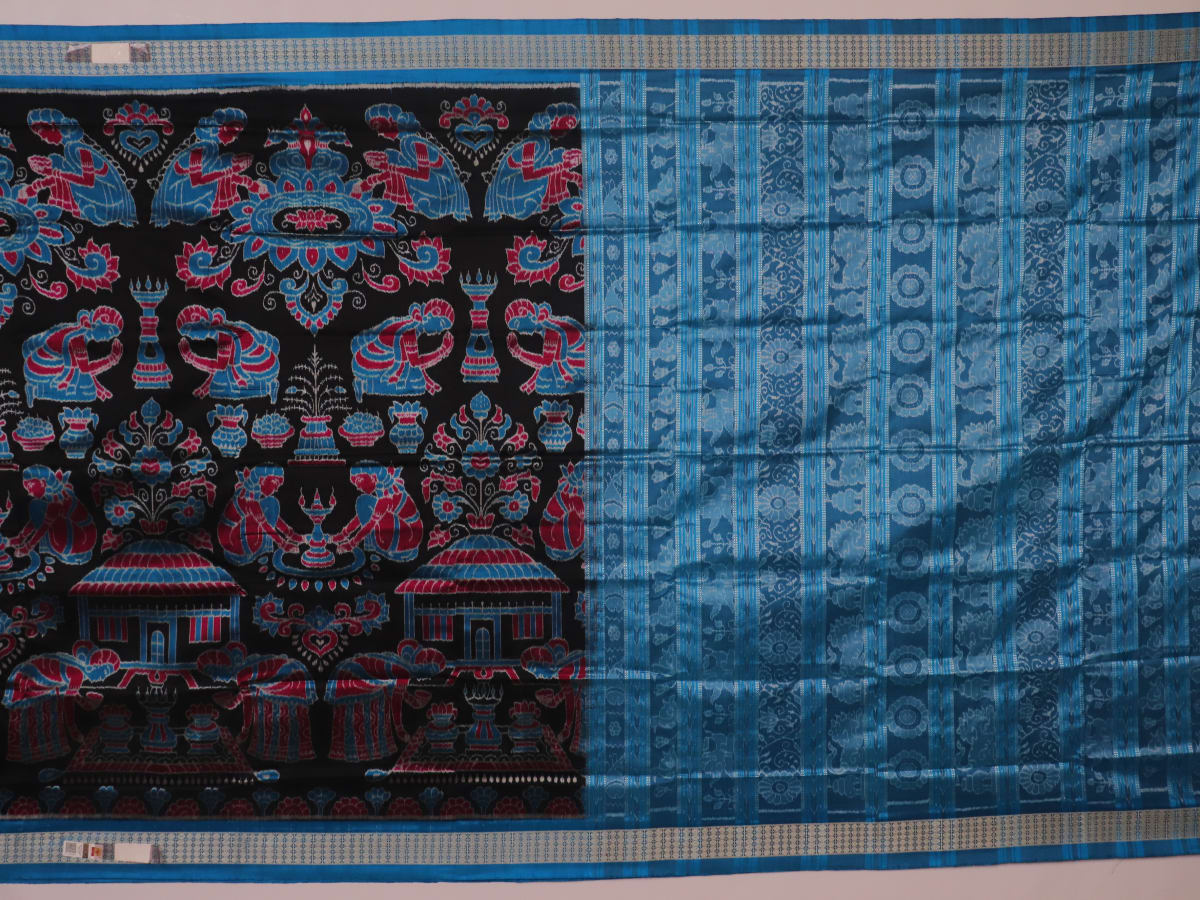 Close-up of black Sambalpuri silk saree fabric texture, showcasing the weave and subtle motif details.