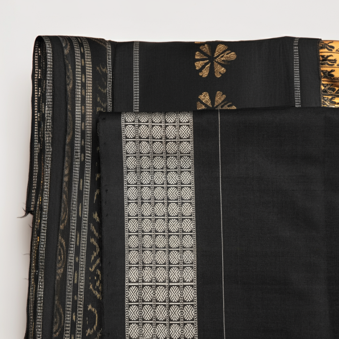 Close-up of the lustrous black Sambalpuri silk fabric, revealing its luxurious texture and fine weave.