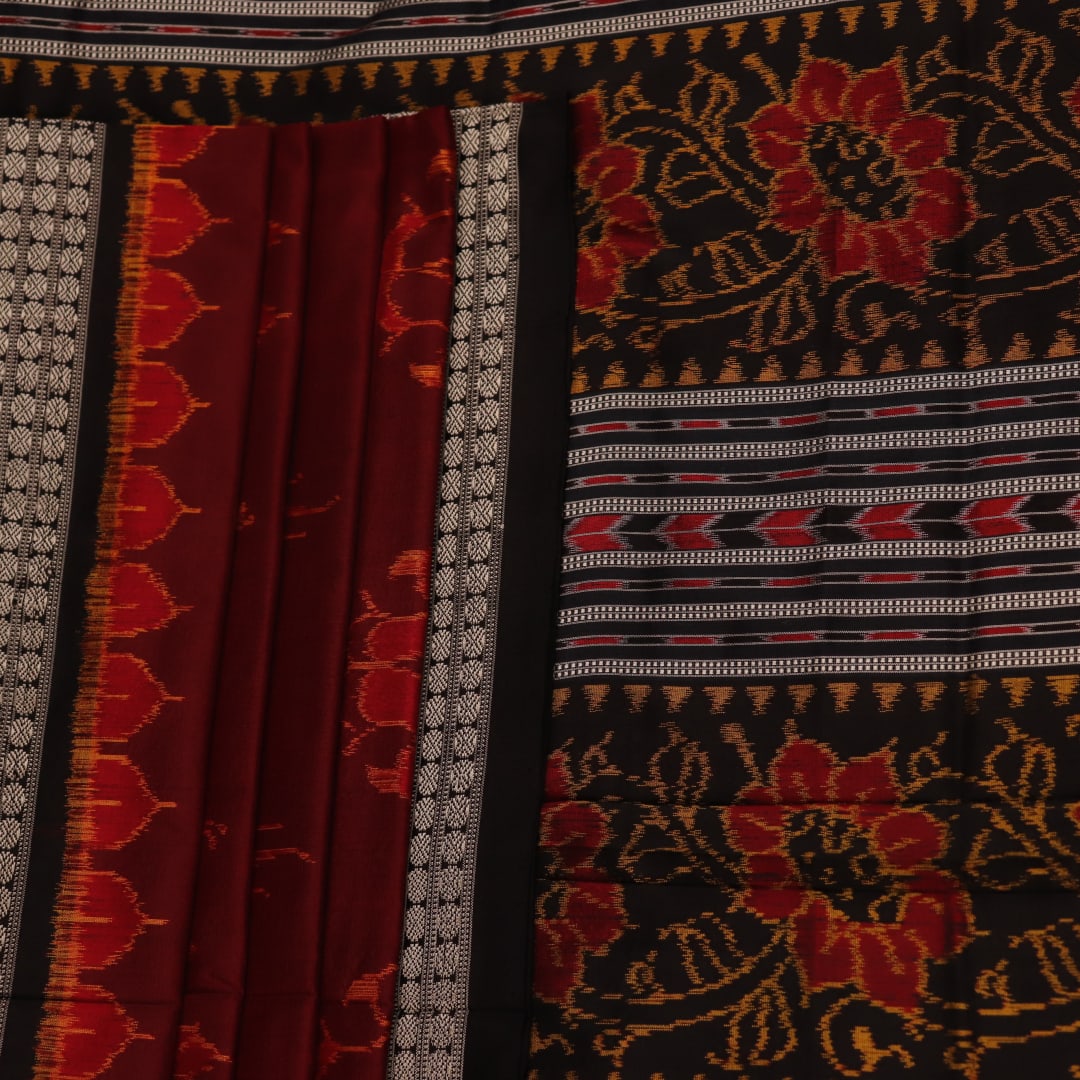 Close-up of intricate motifs on a maroon Sambalpuri silk saree