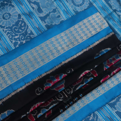 Close-up of black Sambalpuri silk saree fabric texture, showcasing the weave and subtle motif details.