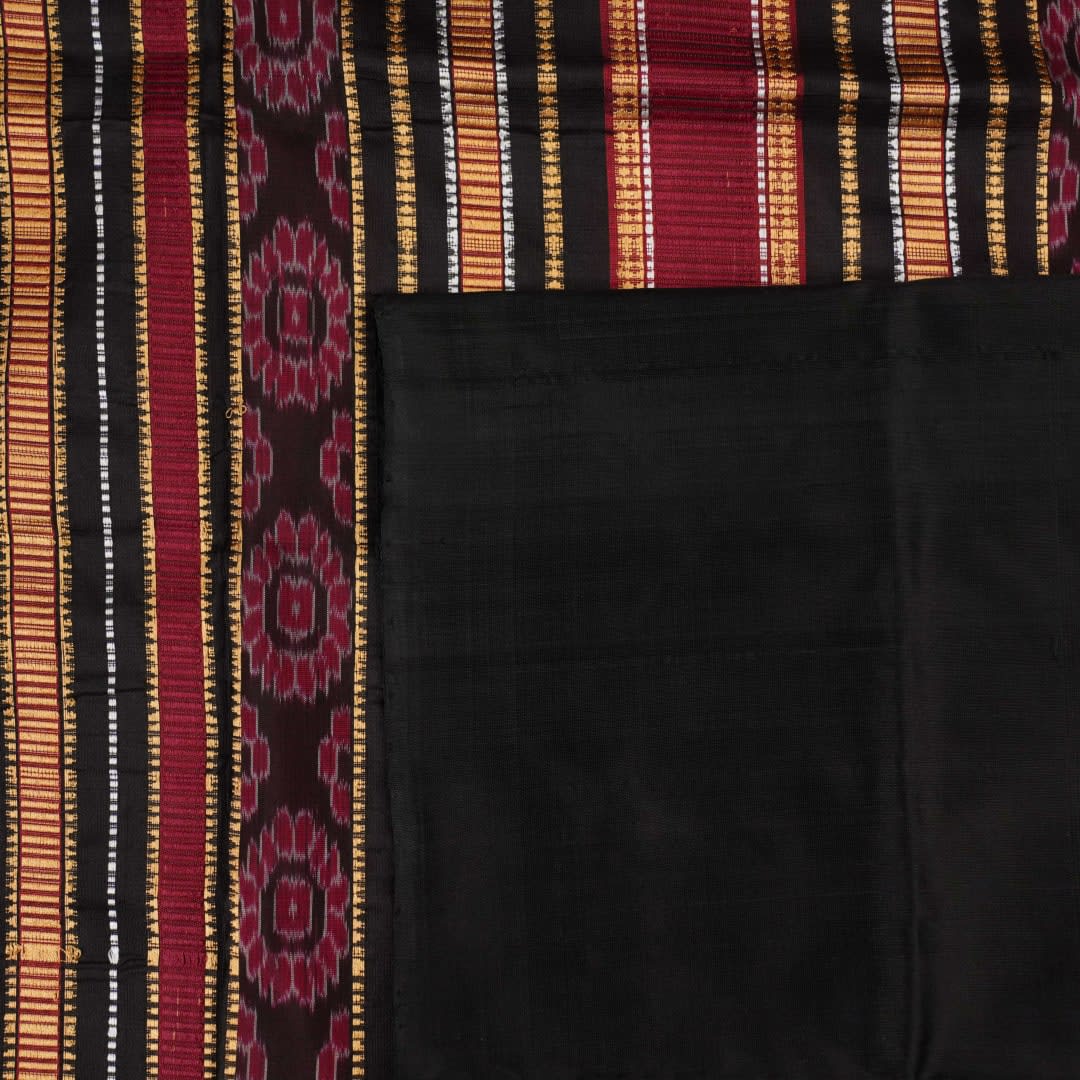 Detailed view of hand-woven silk fabric texture and butta patterns on a red Sambalpuri saree.